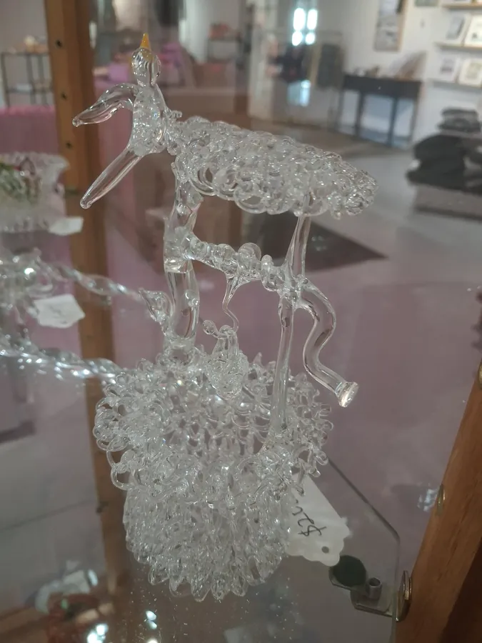 Clear glass peacock sculpture with lattice feathers and gold beak